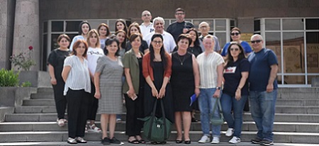 Un grupo de personas de pie dentro de un edificio y posando para una foto.