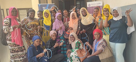 Un grupo de mujeres posando para una foto con cables en sus manos.
